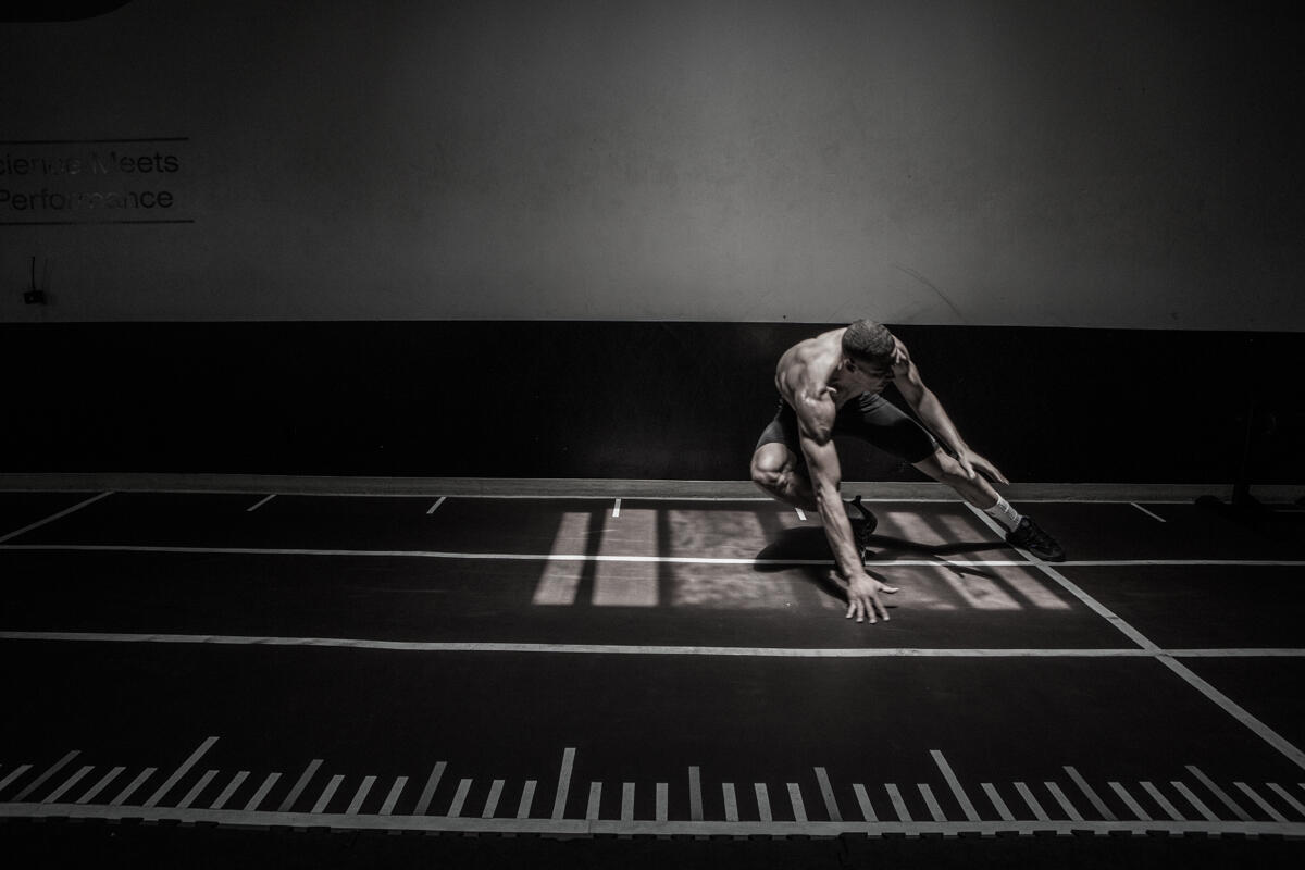 Athlete in a deep deceleration position on the P3 track, black and white